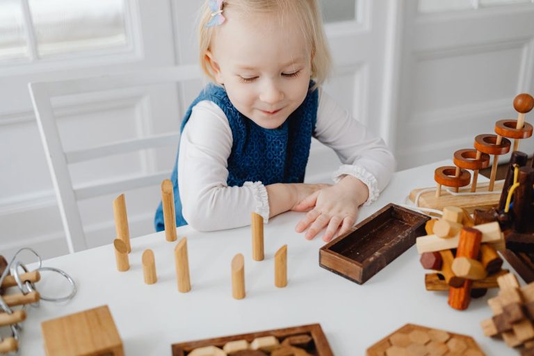 Cute young girl playing with wooden toys indoors, smiling and learning.