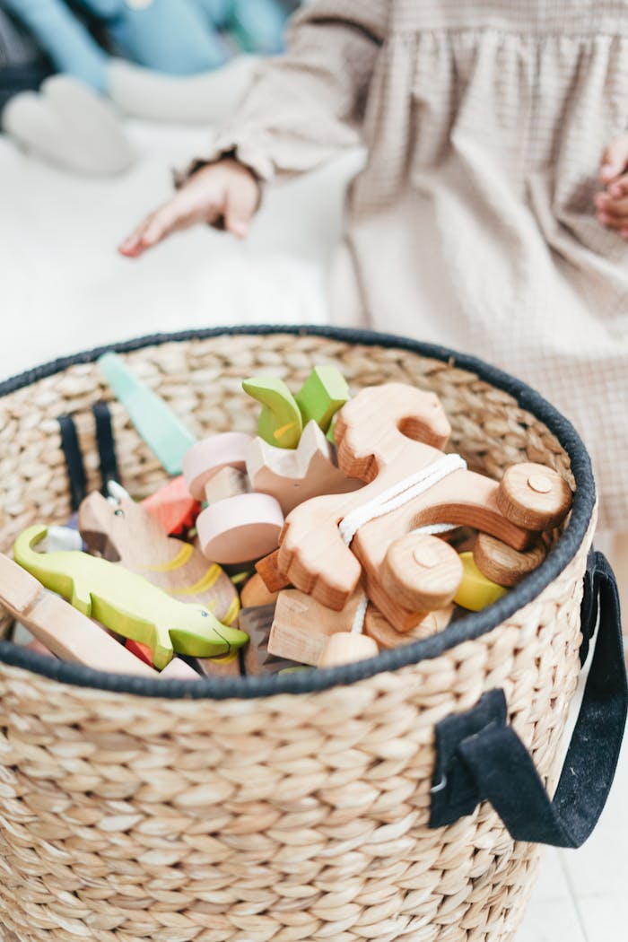 A childs hand reaching for colorful wooden toys in a woven basket, capturing playtime joy.